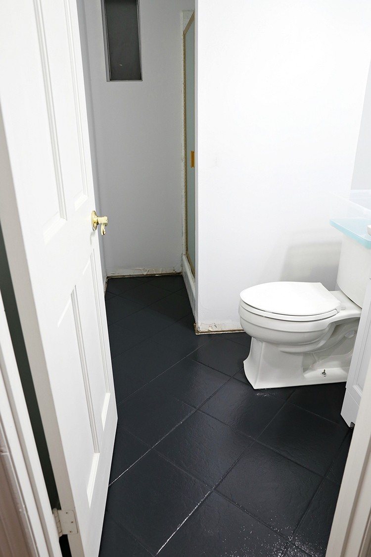 Bathroom tile floor with black chalked paint coverage before adding painted stencil design
