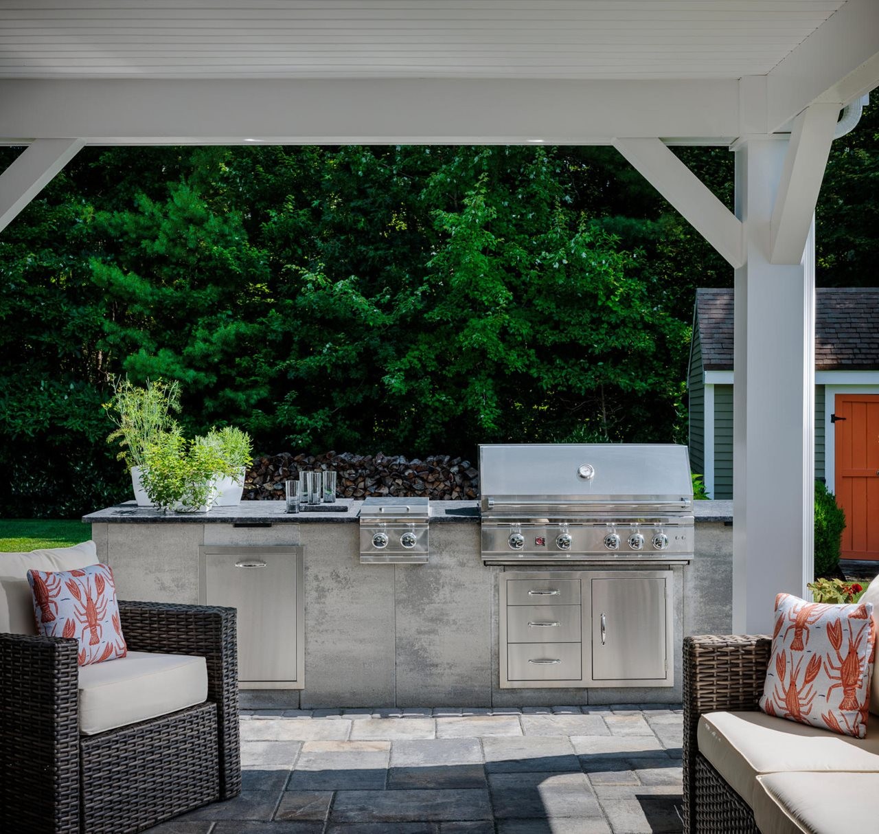 Lush backyard with outdoor kitchen and shaded seating area.