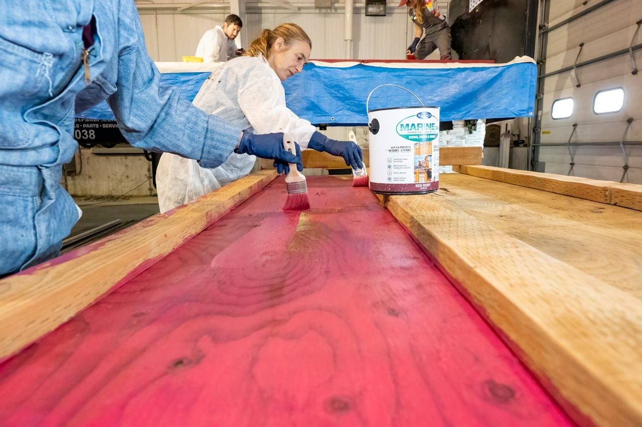 People painting the wood sides of a truck with Marine Grade paint.