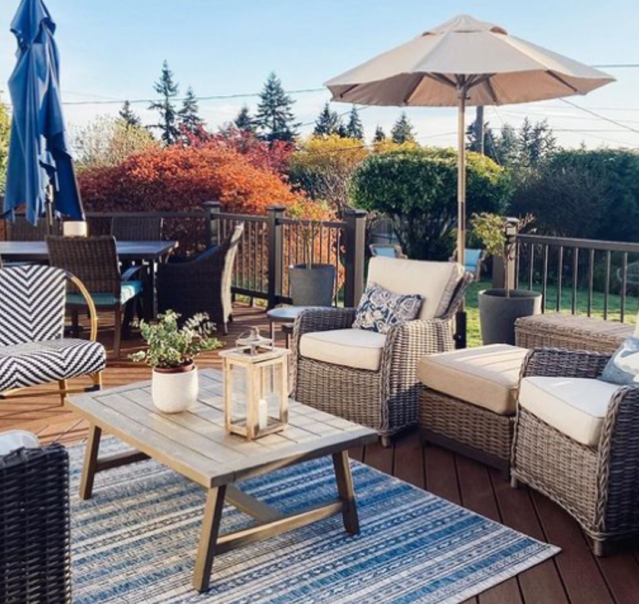 Deck with custioned wicker furniture and big sun umbrella.