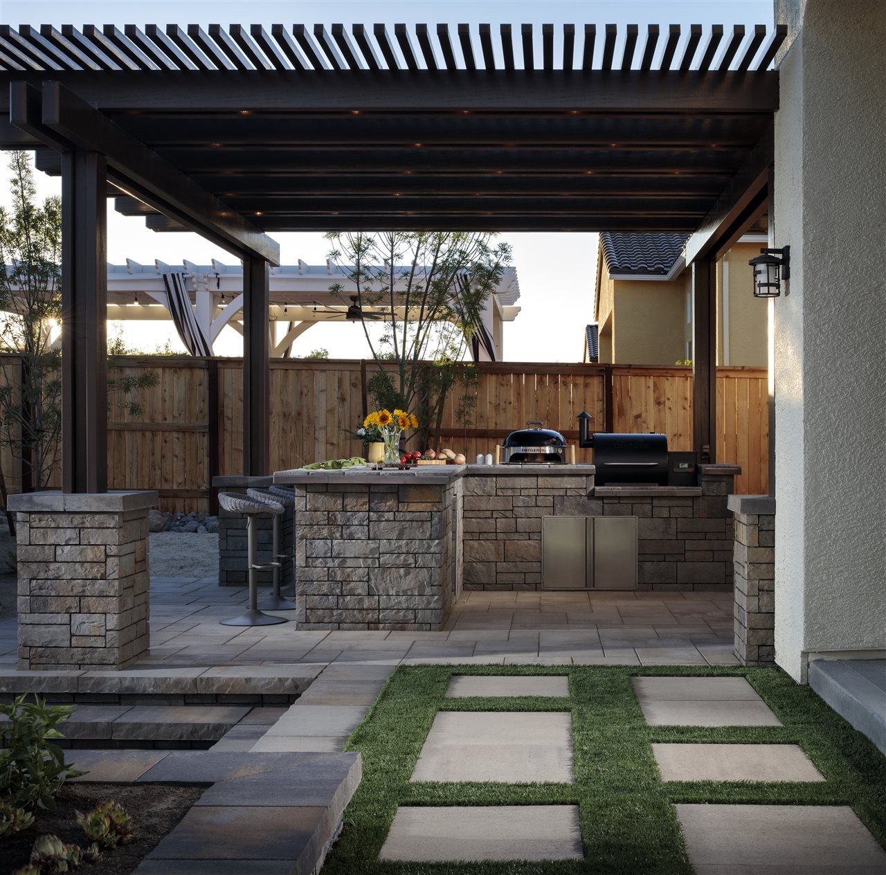 Back yard privacy fence with pergola, patio, outdoor kitchen and bar area.