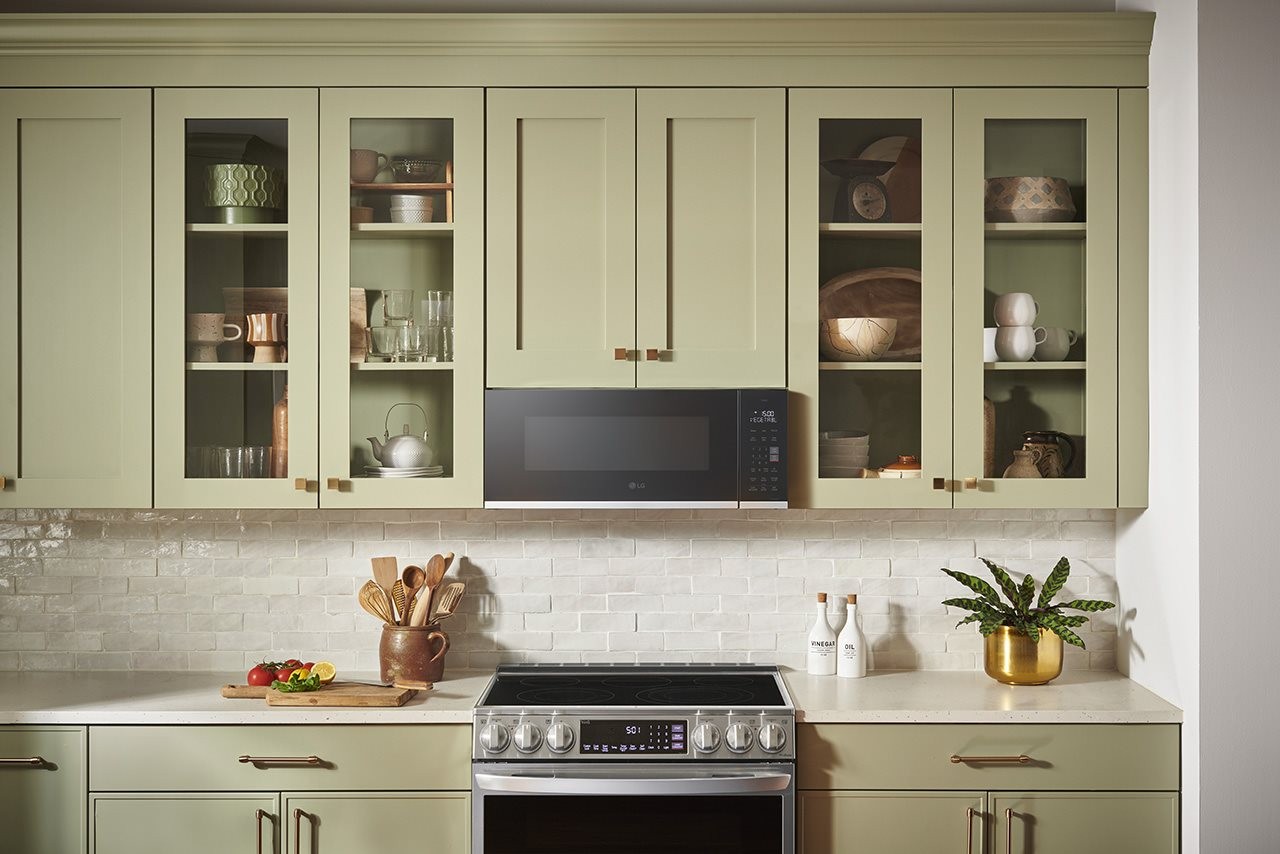 Celery green shaker style cabinetry in a kitchen with an LG range and mircowave.