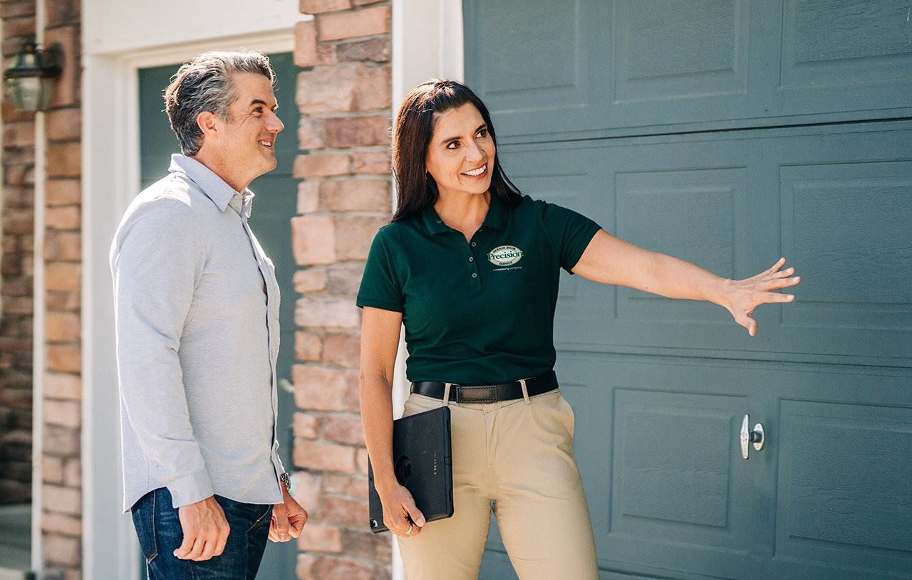 Representative from Precision garage door outside with homeowner talking about garage door.