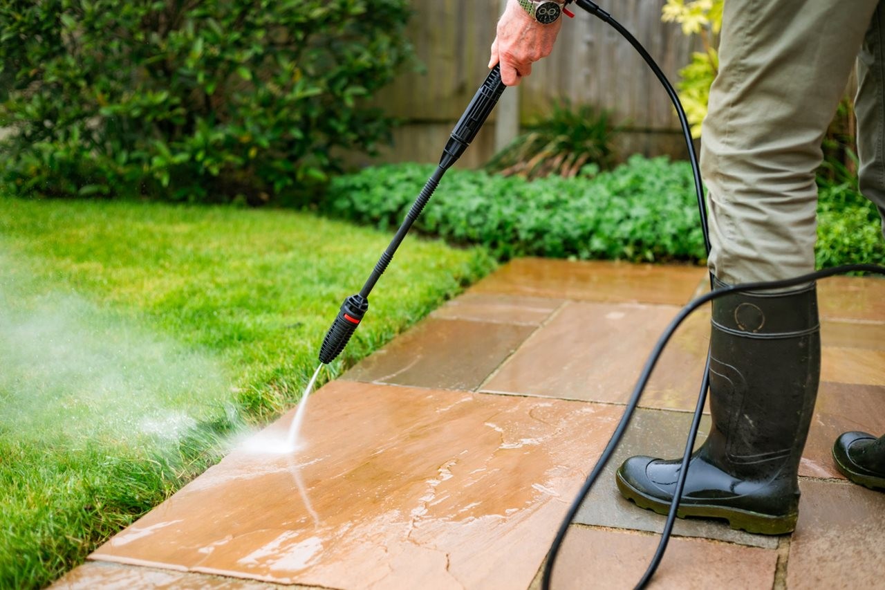 Man power washing his patio
