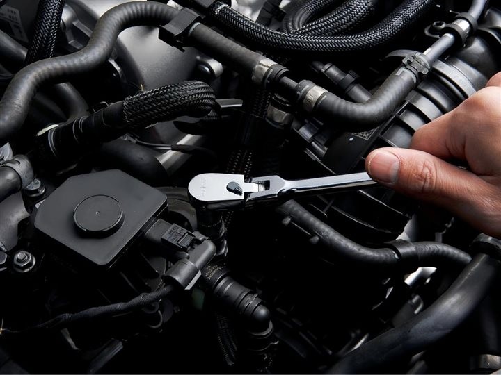 Man using flex head rachet wrench on Engine