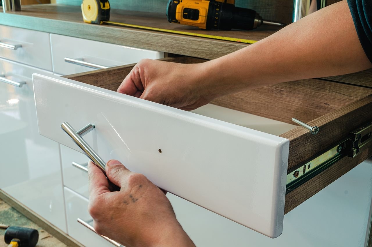 Person fixing a handle on a drawer