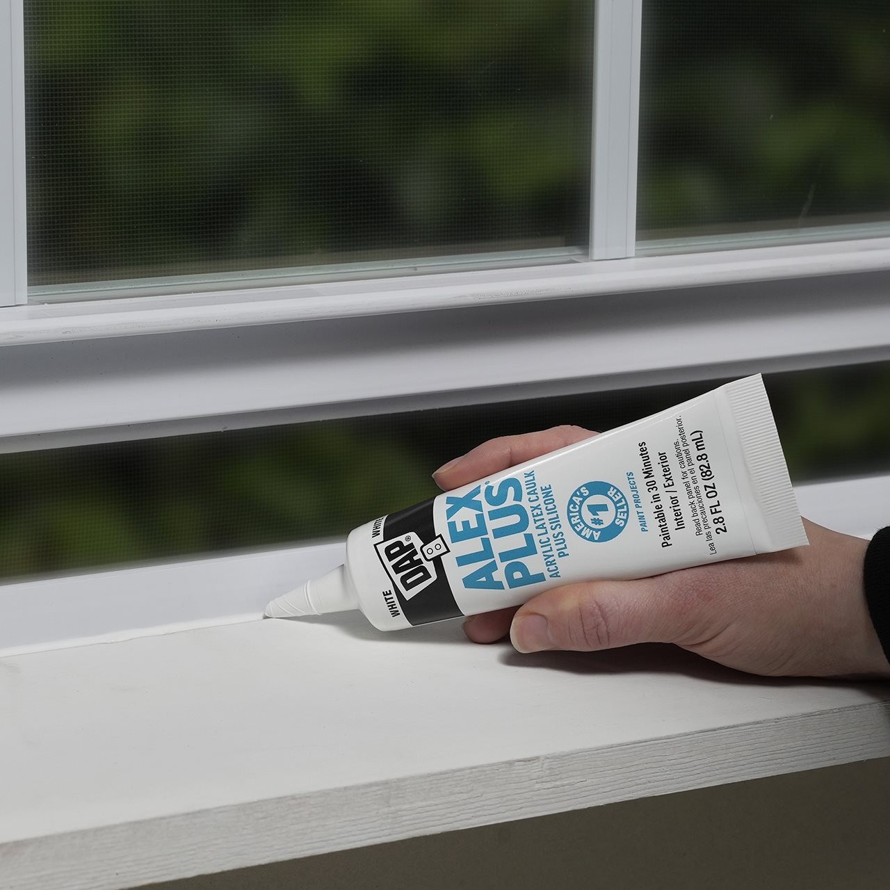 Person using Alex plus calking to seal interior windows
