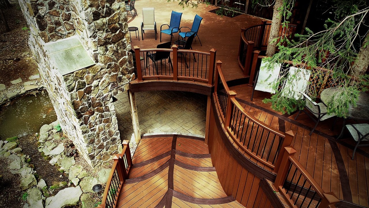 Beautiful custom deck over a stone patio.