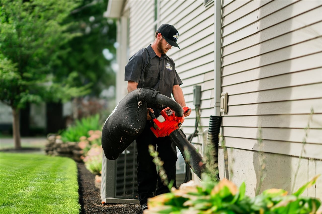 Dryer Vent Wizard Representative using a leaf vacuum on the outside vent to clean out dry lint.