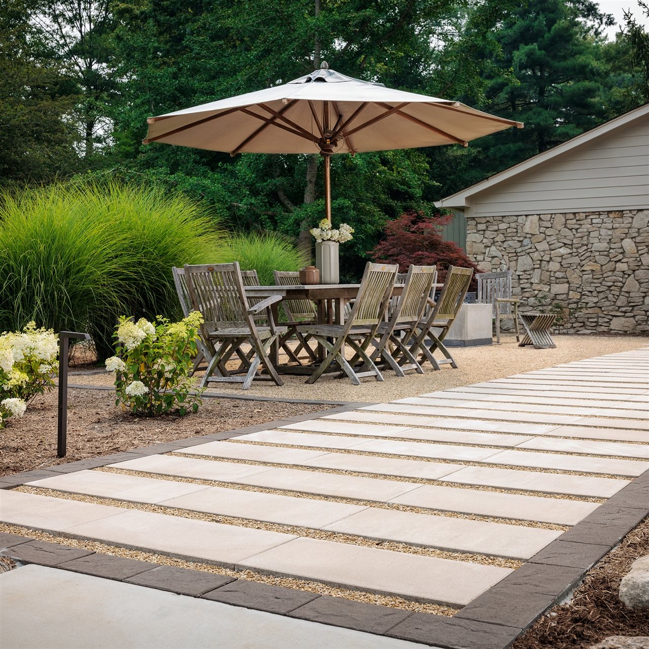 Belgard dimentional slab patio with outdoor dinning area and beautiful plantings.