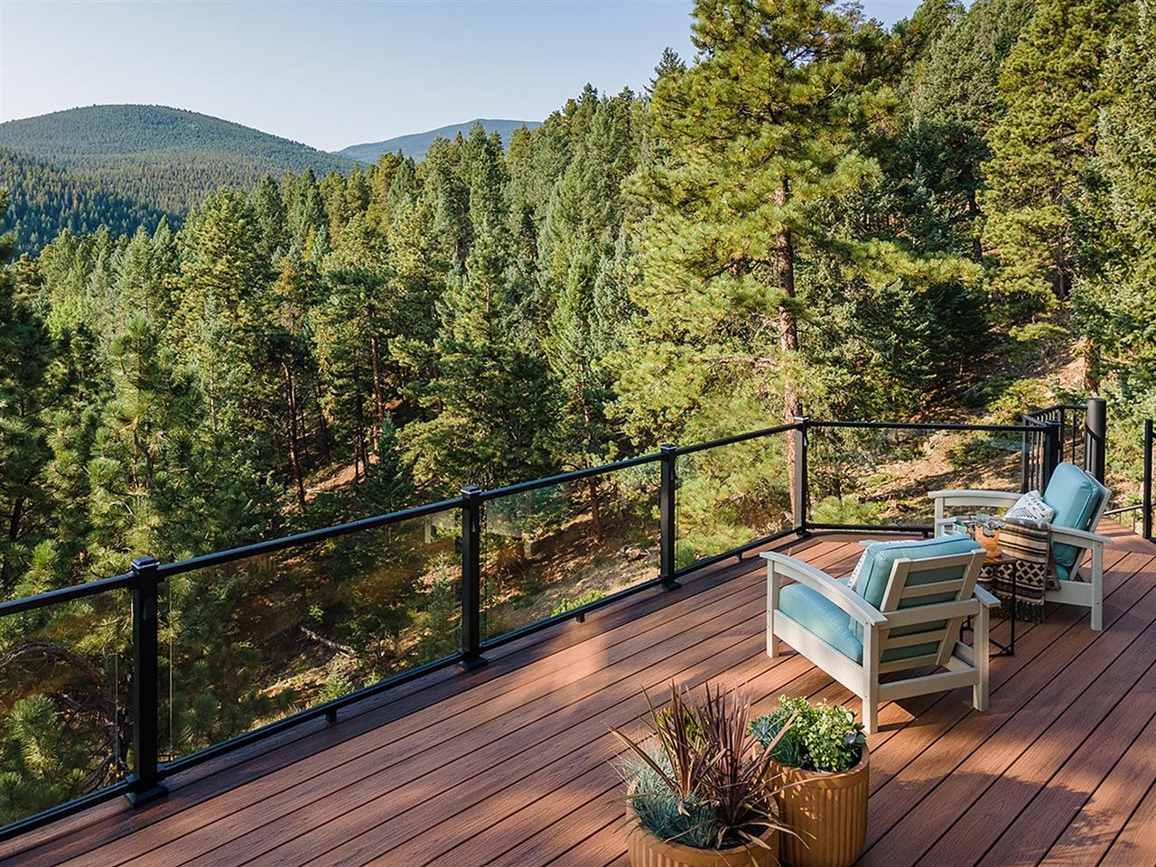A wooden patio overlooking a hilly forest.