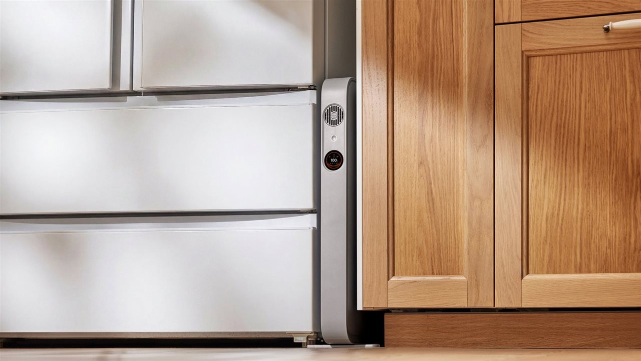 A FridgeGuard at work between a kitchen counter and a refrigerator.