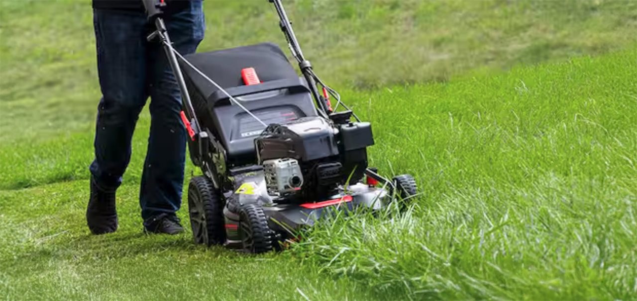 Person running a lawn mower in the tall grass.